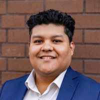 Photo of Eric in a blue blazer with a brick wall in the background